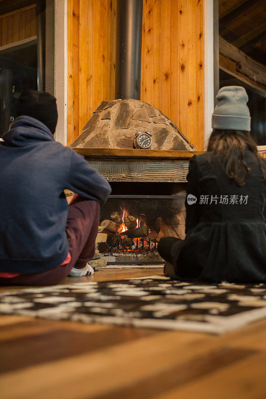 男孩和女孩在壁炉前享受山的寒冷