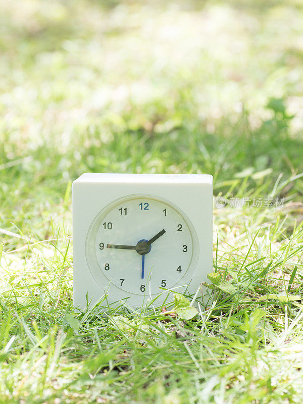 草坪上的白色简单时钟，1点45分，1点45分