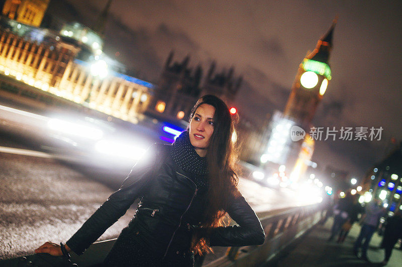 一个年轻女子晚上在伦敦等出租车