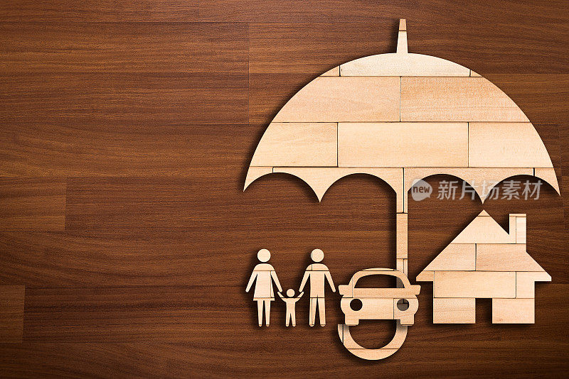 木制伞下的家庭剪影-保险概念