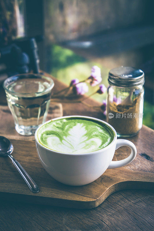 绿茶热饮拿铁白杯放在木桌上，香气馥郁，休闲时光在咖啡厅咖啡厅