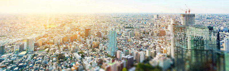 全景现代城市天际线鸟瞰鸟瞰图在戏剧性的太阳和早晨蓝色多云的天空在东京，日本。微型Tilt-shift效应