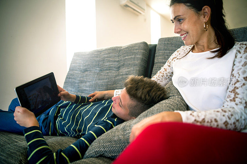 母亲和儿子在玩电子平板电脑