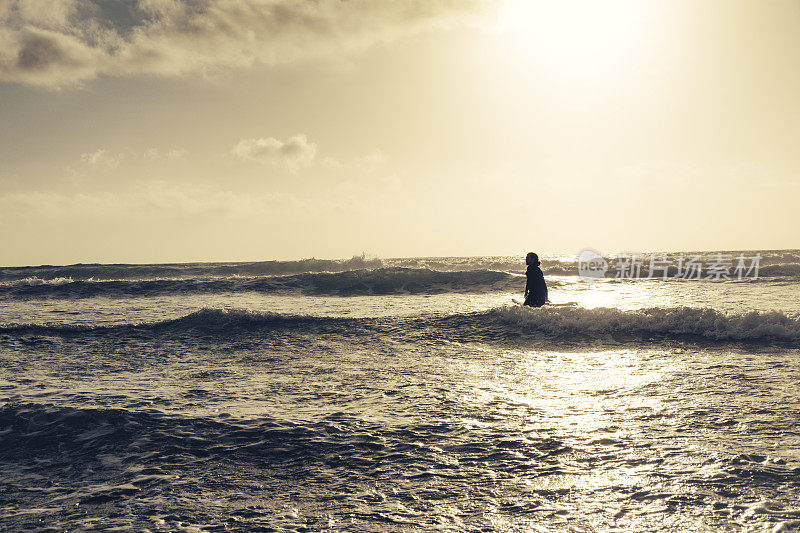 康沃尔纽基菲斯特拉海滩，冲浪者涉水进入大海。