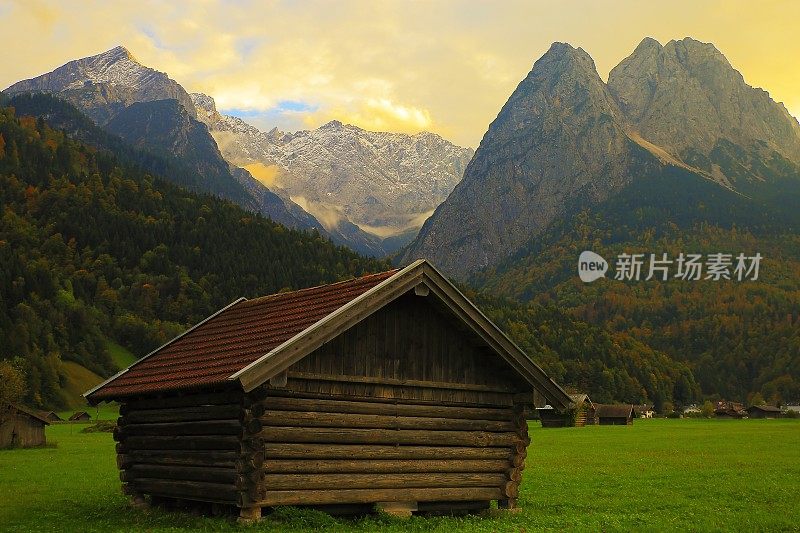 德国巴伐利亚的加尔米施，金色黎明的巴伐利亚阿尔卑斯山和木制谷仓