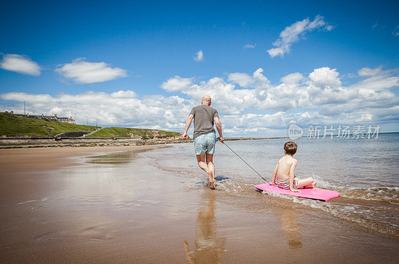 父亲与孩子们在海滩上共度时光