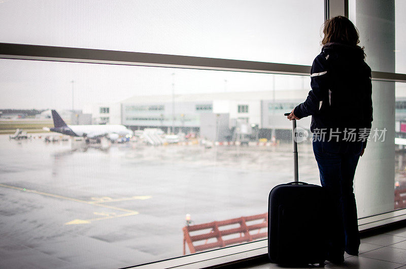 一名女游客望着窗外的机场复印空间
