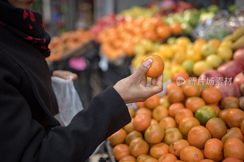 肤色不同的妇女在传统市场挑选水果