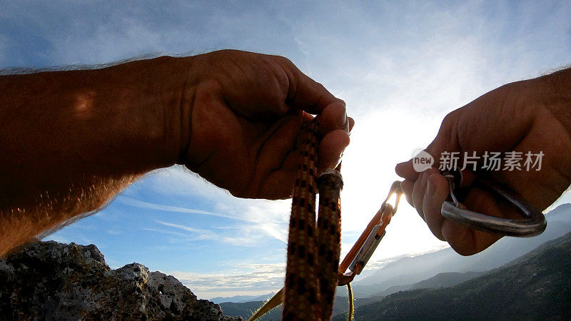 登山者在岩顶放置装备，以确保绳索安全