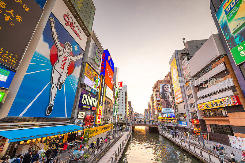 在日本大阪的道顿堀，五颜六色的广告牌照亮了大阪夜市周围的商店和零售店