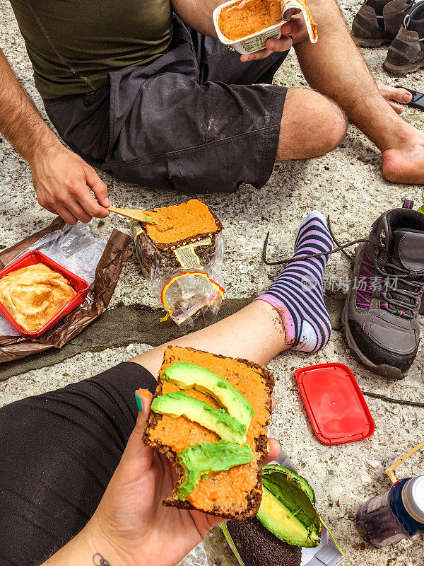 一对年轻的徒步旅行者在山顶上用餐