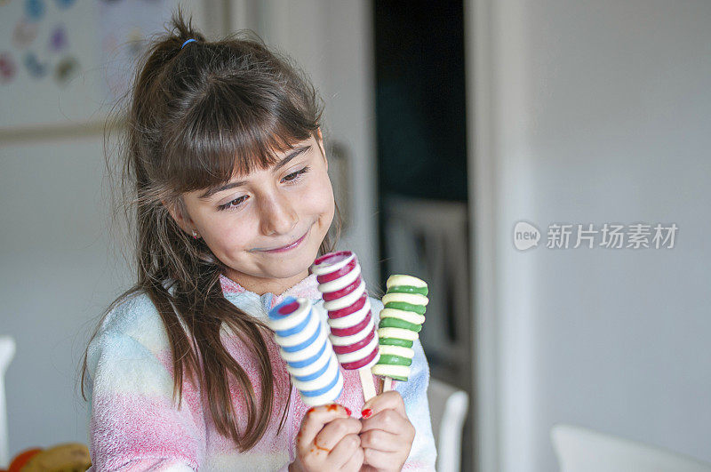 快乐的小女孩在厨房里吃着冰淇淋