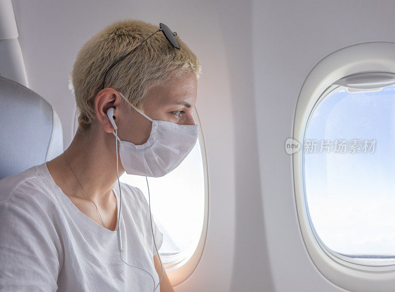 一个戴着防护面具的女人在飞机上向外看