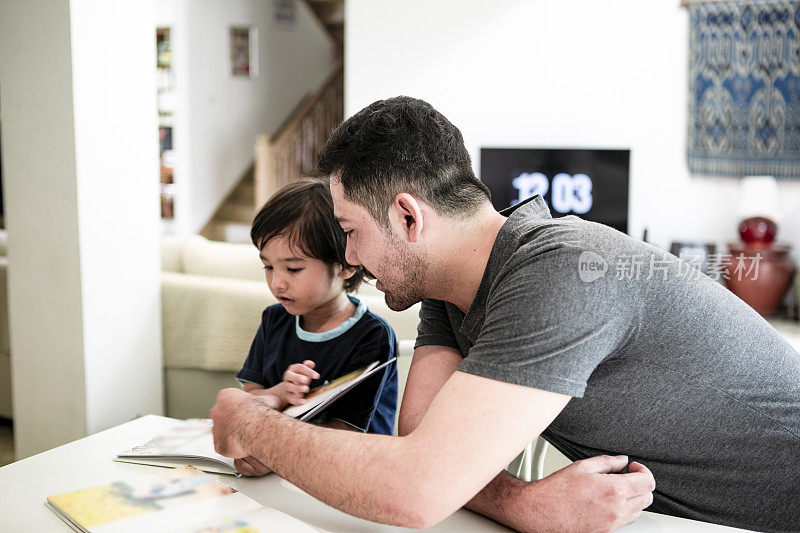 阿拉伯父亲读书与儿子在家