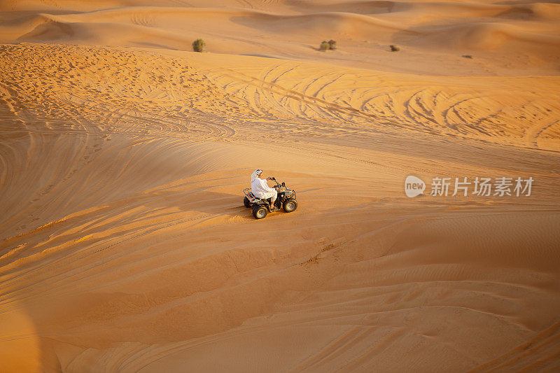 在迪拜附近的一个沙漠野生动物园里，一名阿联酋人骑着四轮自行车穿过沙丘