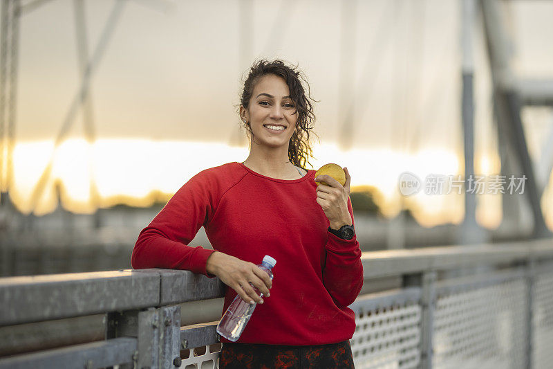 快乐运动女性在户外运动训练后吃健康零食的肖像