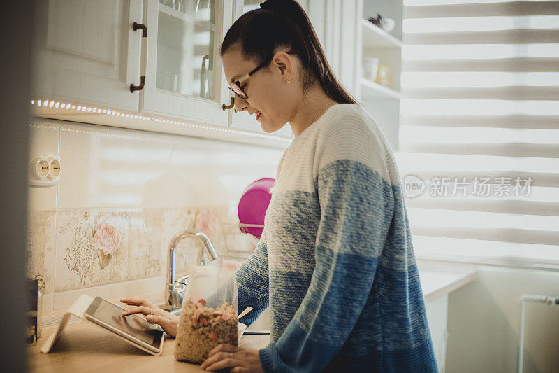 年轻女子与一杯麦片粥-妇女吃麦片的早餐-女孩手持自制格兰诺拉麦片-健康的零食或早餐在早上