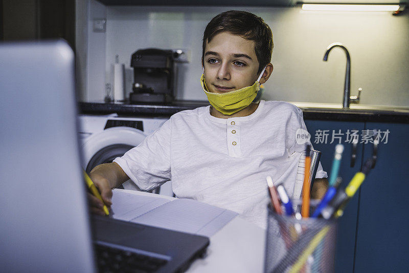 回到学校。可爱的男孩戴着防护面具在家学习。在线教育冠状病毒流行。新型冠状病毒肺炎副本的空间。