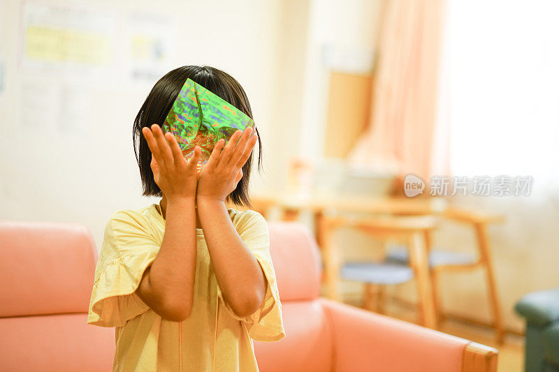 女孩们的肖像戴着面具玩着全息折纸遮住自己的脸