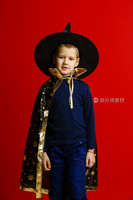 一个穿着巫师服装的男孩，背景是红色的