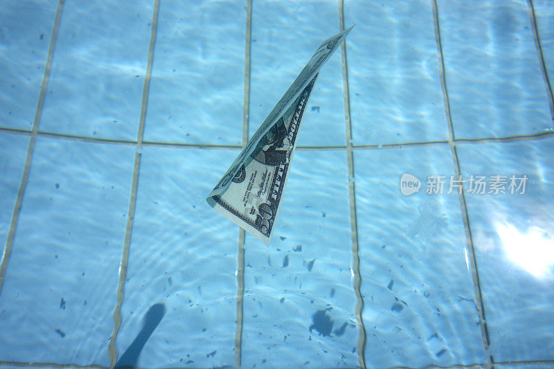 美钞在清澈湛蓝的水面上游泳