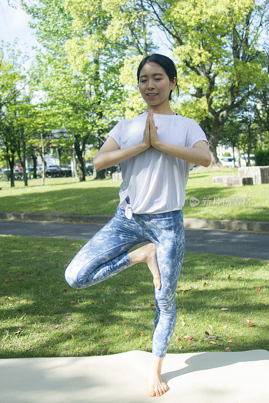 正面的年轻成年妇女树摆姿势户外