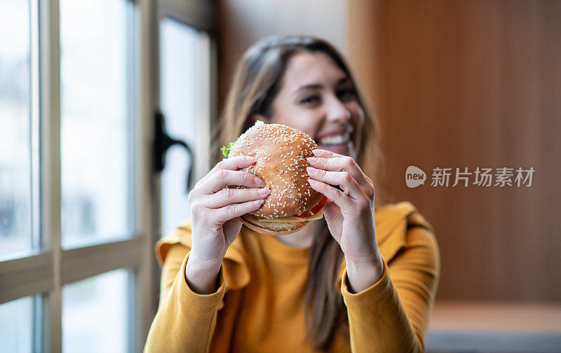 年轻女子喜欢吃汉堡。