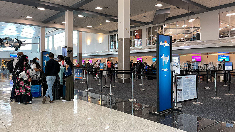 在繁忙的机场，人们在忠诚航空公司的值机柜台等待取票。