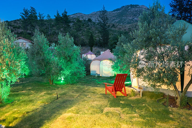 帐篷在露营区过夜，空的露营椅在帐篷旁。
