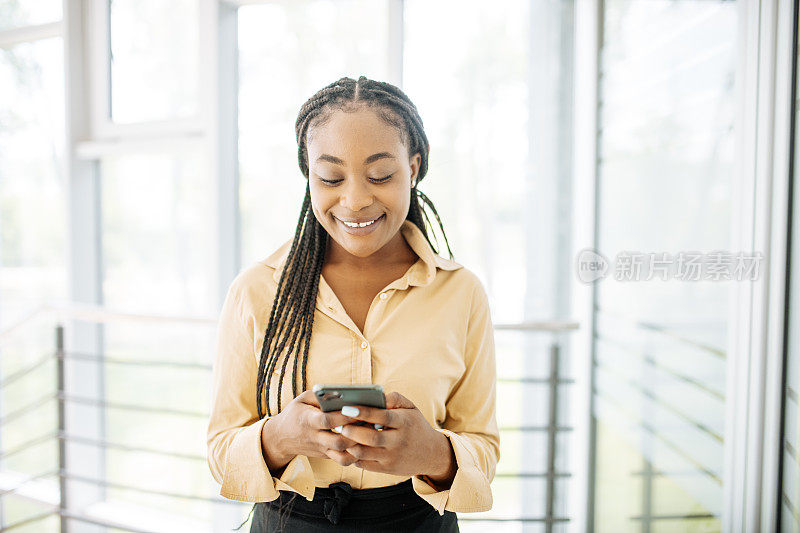 非裔美国女商人使用智能手机发短信的肖像