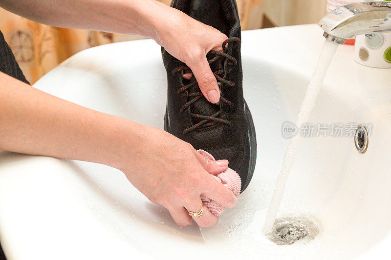 女人在水流下用抹布给男人洗鞋