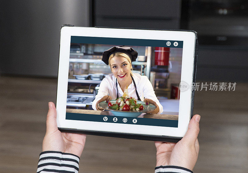 平板电脑屏幕上的厨师。现场烹饪视频。准备素食沙拉的人的照片。
