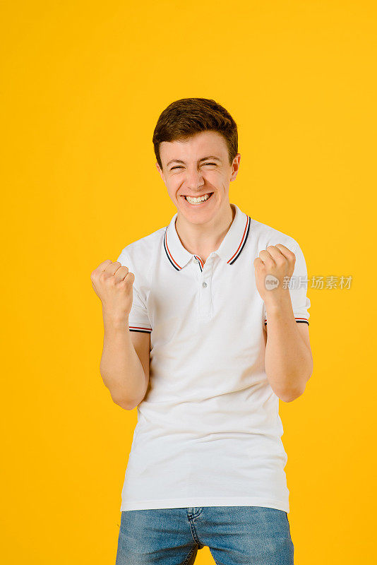 一个穿着白色t恤的快乐的年轻人的肖像上挂着黄色的微笑和大笑