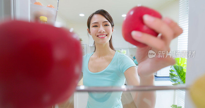 女人从冰箱里拿苹果