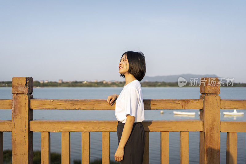 一位亚洲妇女在美丽的河边眺望远方