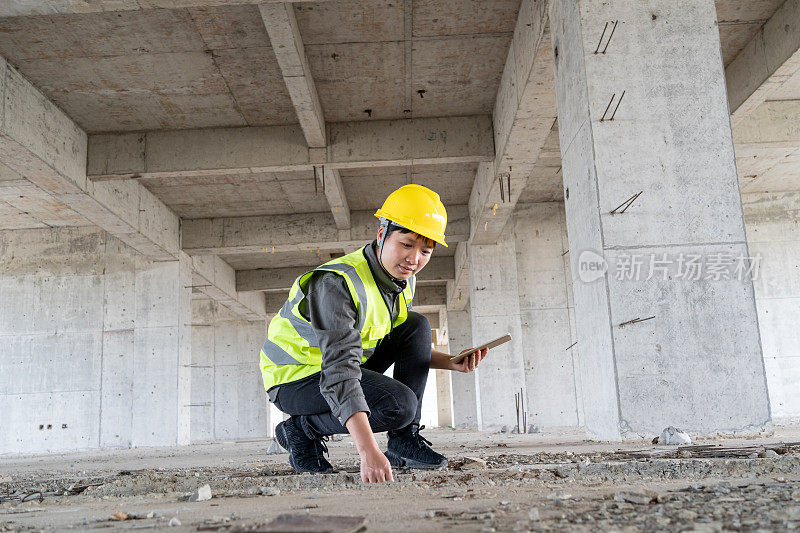 女工程师检查混凝土建筑施工质量