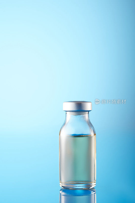 冠状病毒疫苗:蓝色背景的注射器和小瓶
