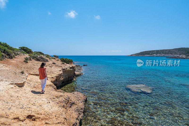 女旅行者从多石的地方眺望大海