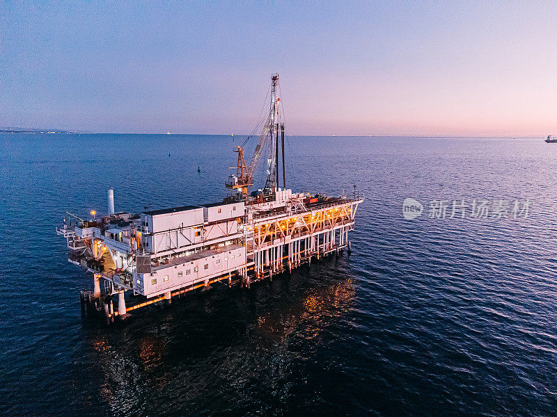 加利福尼亚州亨廷顿海滩日落处的海上石油钻井平台