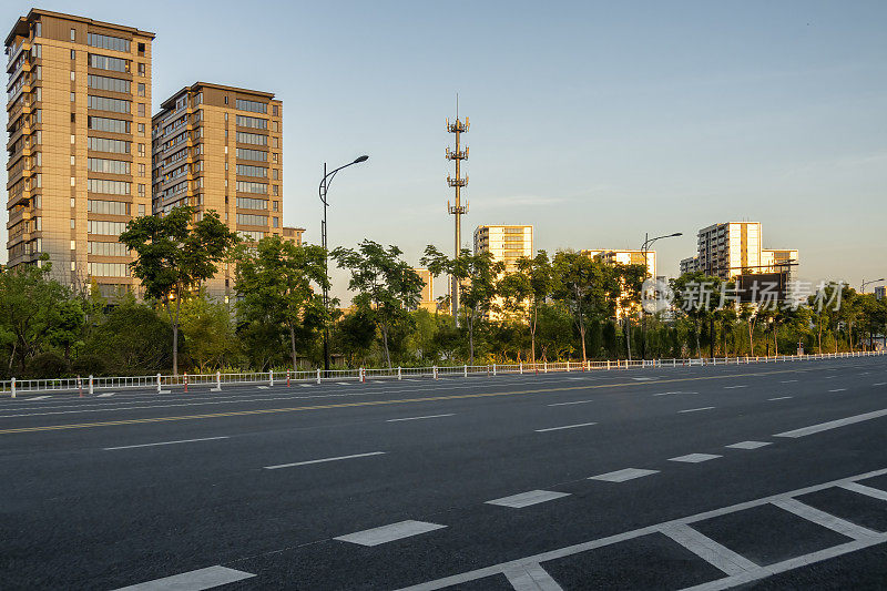 夕阳照在空路旁楼上的住宅上