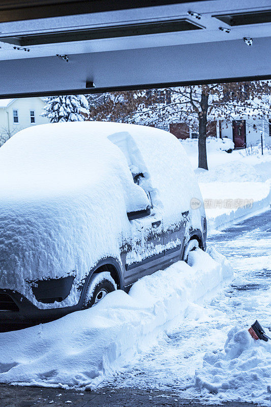 车道上的汽车被深埋在暴风雪中