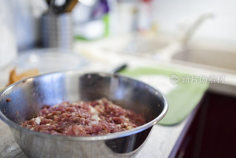 厨房里金属碗里的生肉末，特写。