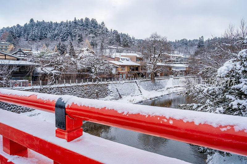 高山村雪与红色木桥和溪水，日本