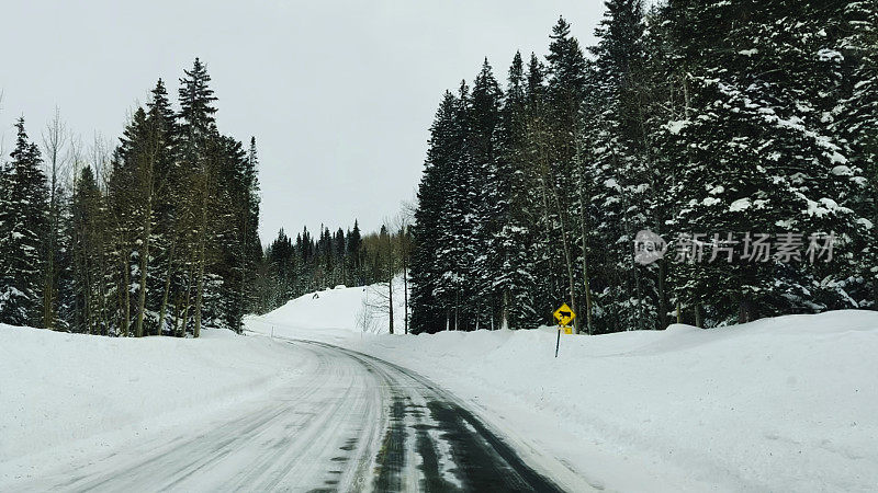 司机POV下雪的冬季山路与高雪堤在科罗拉多州西部照片系列