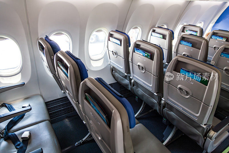 飞机客舱内的经济舱座位，座位之间的距离较小。