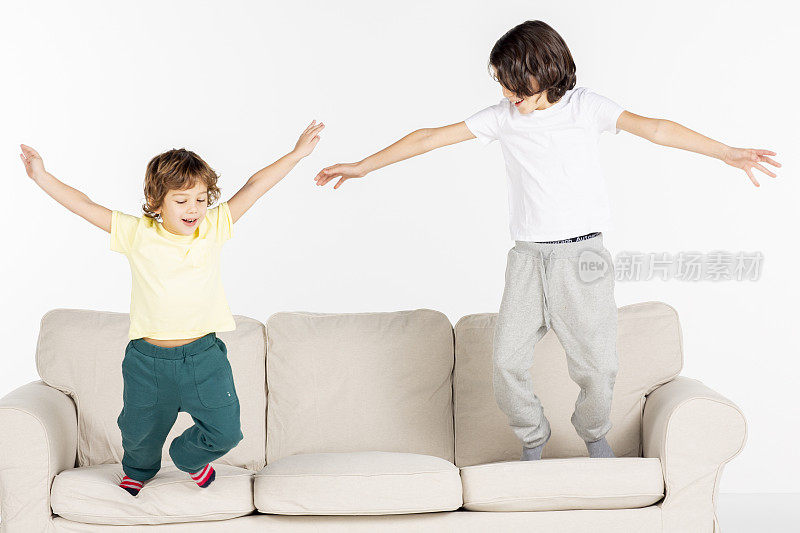 两个男孩在沙发上玩。
