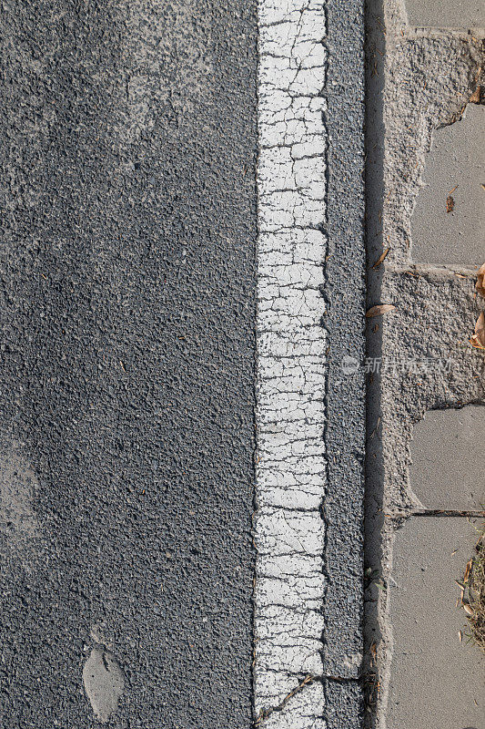 航拍特写:柏油路上的白色道路标记和路肩铺路石