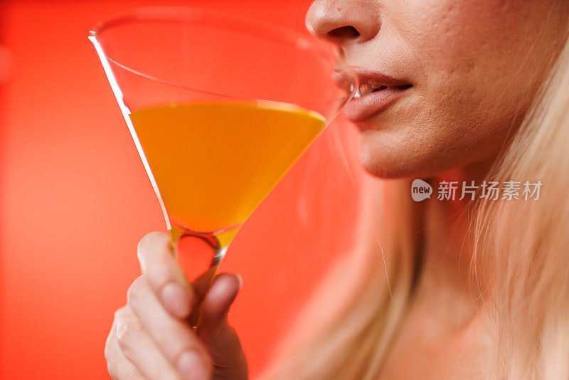 酷酷的金发女郎在喝橙汁马提尼