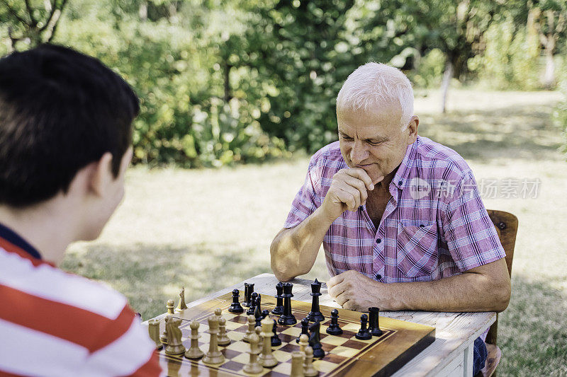 爷爷和孙子在一起下棋。