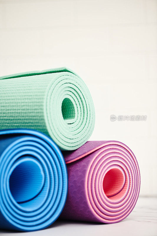三个瑜伽垫或运动垫卷起来，留出空间供抄写。健康的生活方式
